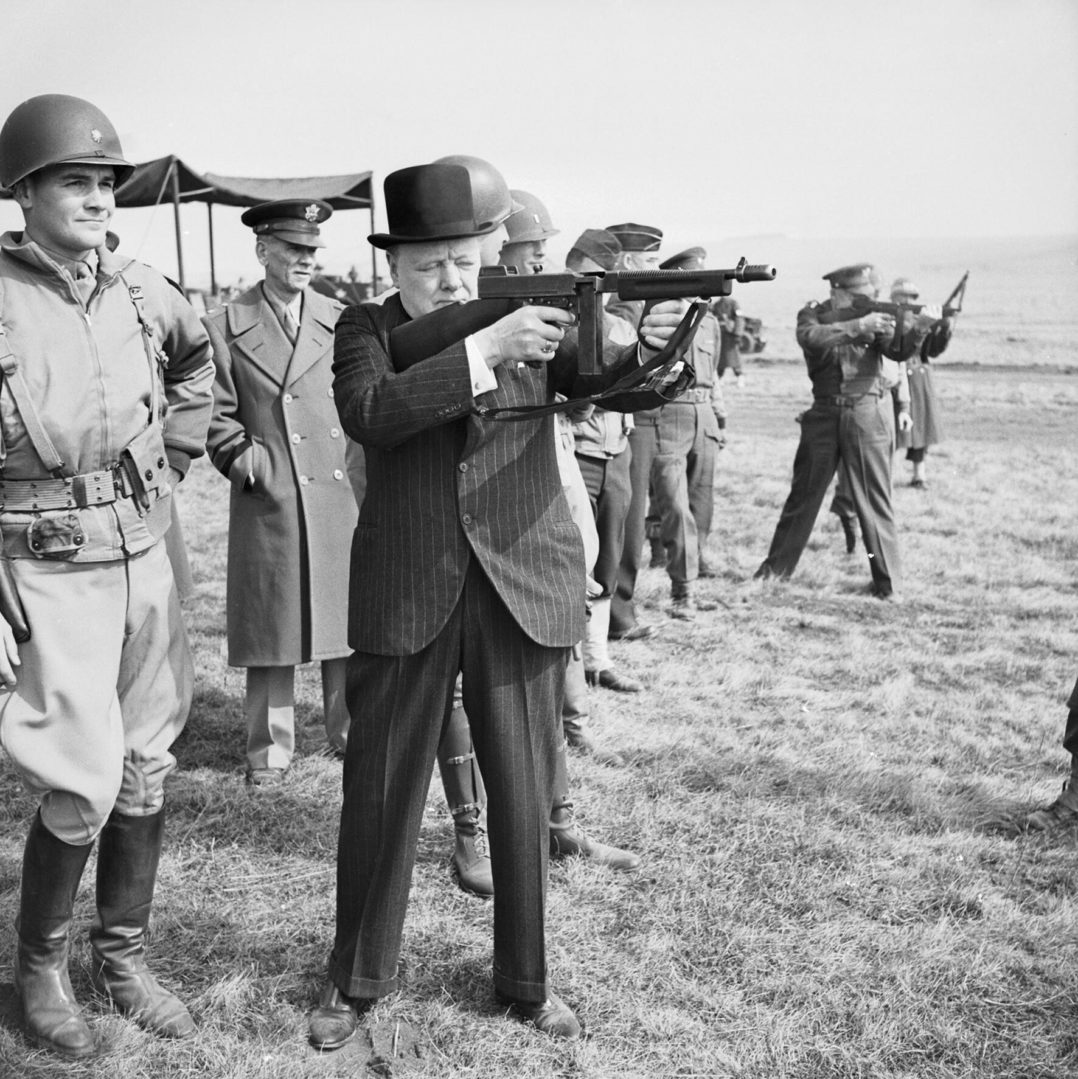 Winston Churchill fires a Thompson submachine gun alongside the Allied Supreme Commander, General Dwight D Eisenhower, during an inspection of US invasion forces, March 1944. The Prime Minister Winston Churchill fires a Thompson 'Tommy' submachine gun alongside Supreme Allied Commander of the Allied Expeditionary Force General Dwight D Eisenhower as American soldiers look on in southern England in late March 1944.