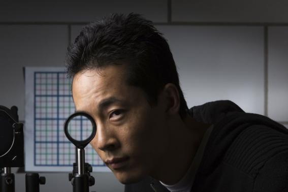 Handout photo of University of Rochester Ph.D. student Joseph Choi demonstrating a cloaking device using four lenses in Rochester