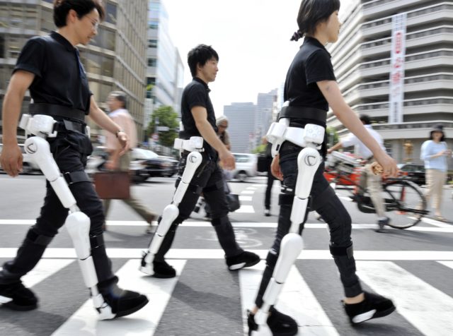 (FILES) This file picture, taken on August 3, 2009 shows Japan's robotics venture Cyberdyne employees wearing the robot-suit "HAL" (Hybrid Assistive Limb) as they walk on a street in Tokyo for a demonstration. HAL was given a global safety certification on February 27, 2013, paving the way for the nation's cutting-edge human robotic technology worldwide. The certificate was given based on a draft version of ISO 13482, the first global safety standard for personal robots.    AFP PHOTO / FILES / Yoshikazu TSUNO