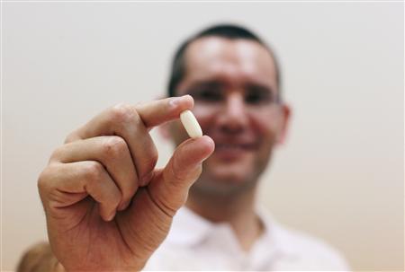 Nadav Kidron, CEO of Oramed Pharmaceuticals, shows an insulin pill as he poses for a photo at the company's offices in Jerusalem September 29, 2013. REUTERS/Baz Ratner